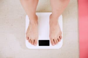 Best Smart Scales person standing on white digital bathroom scale